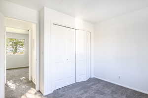 Unfurnished bedroom with a closet and carpet flooring