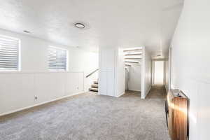 Unfurnished bedroom featuring heating unit, a textured ceiling, and carpet floors