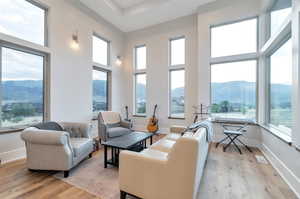 Living room with a mountain view, a high ceiling, and light hardwood / wood-style floors