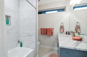 Full bathroom with tile patterned floors, shower / bathtub combination with curtain, toilet, and vanity