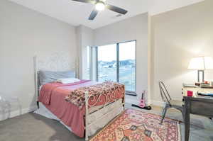 Carpeted bedroom featuring ceiling fan