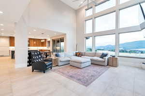 Living room featuring plenty of natural light, a mountain view, ceiling fan, and a high ceiling