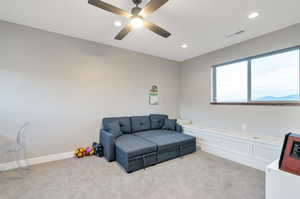 Interior space featuring light colored carpet and ceiling fan