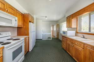 Kitchen featuring sink and white appliances