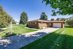 Ranch-style house with a garage and a front lawn