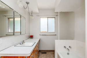 Bathroom featuring a bathing tub and vanity