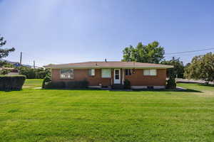 Rear view of property with a yard