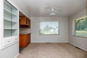 Unfurnished living room featuring light colored carpet and ceiling fan