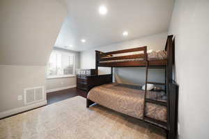 ADU - Bedroom with vaulted ceiling and dark wood-type flooring