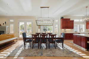 Dining room featuring an inviting chandelier, sink, a healthy amount of sunlight, and crown molding