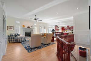 Family room with ornamental molding, ceiling fan, and light hardwood / wood-style flooring