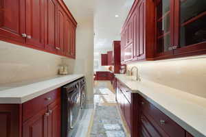 Butlers Pantry with independent washer and dryer, tasteful backsplash, and sink