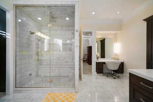 Primary Bathroom featuring ornamental molding, vanity, and a shower with shower door