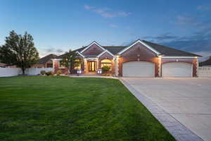 View of front of property featuring a garage and a yard