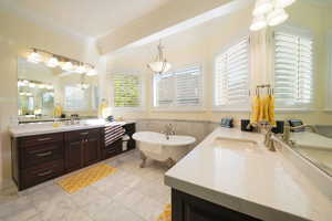 Primary Bathroom with vanity, a bathing tub, and crown molding