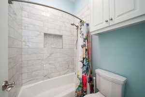 Bathroom featuring shower / bath combo and toilet