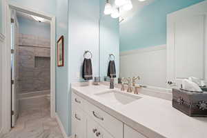 Full bathroom featuring tiled shower / bath combo, vanity, and toilet