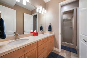 Bathroom featuring a shower with door and vanity