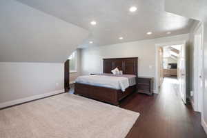 ADU - Bedroom with lofted ceiling and dark hardwood / wood-style flooring