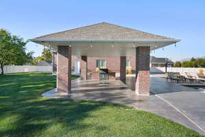 Rear view of house with a patio and a yard