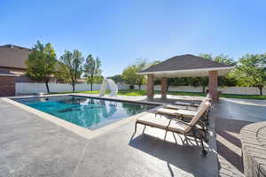 View of swimming pool with a patio, a water slide, a gazebo, and a diving board