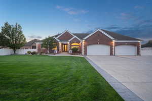 View of front facade featuring a garage and a yard