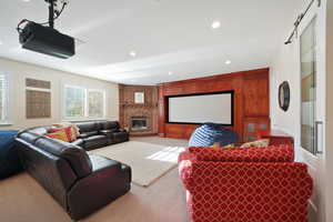 Cinema room with a fireplace and carpet flooring