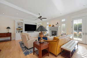 Family room with ceiling fan, light wood-type flooring, and crown molding