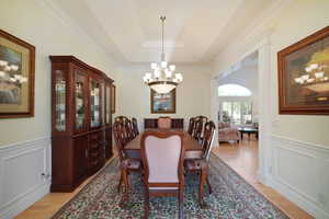 Dining room featuring ornamental molding, an inviting chandelier, and light hardwood / wood-style flooring