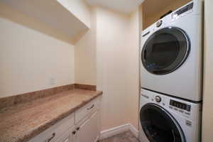 Washroom with cabinets and stacked washer / drying machine