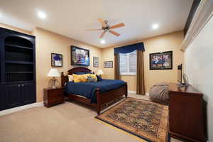 Bedroom with ceiling fan and light colored carpet