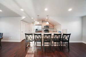 ADU - Dining room featuring lofted ceiling, sink, and dark wood-type flooring