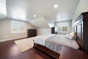 ADU - Bedroom featuring a textured ceiling, vaulted ceiling, and dark hardwood / wood-style flooring