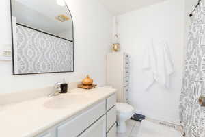 Bathroom featuring tile patterned flooring, vanity, and toilet