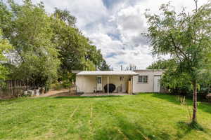 Rear view of property with a patio and a yard