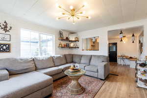 Living room featuring light hardwood / wood-style flooring, a chandelier, and crown molding