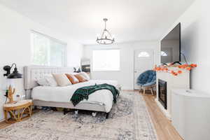 Bedroom with a notable chandelier and light wood-type flooring