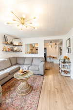 Living room with light hardwood / wood-style flooring and a chandelier