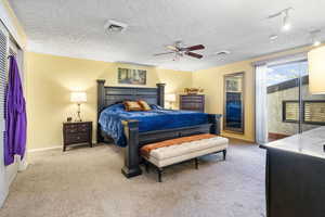 Carpeted bedroom featuring a textured ceiling and ceiling fan