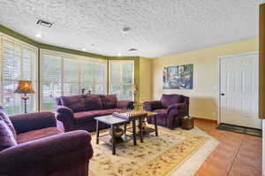 Tiled living room with a textured ceiling