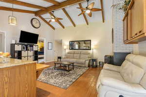 Living room featuring ceiling fan, high vaulted ceiling, and beam ceiling