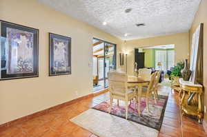 Tiled dining room with a textured ceiling