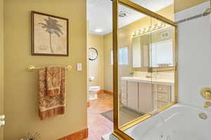 Full bathroom featuring a textured ceiling, separate shower and tub, toilet, and vanity