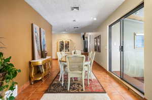 Tiled dining area with a textured ceiling