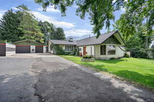 Ranch-style home featuring an outbuilding, a garage, and a front lawn