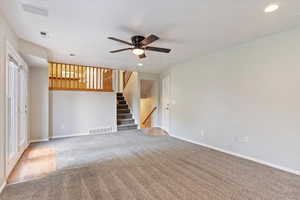 Unfurnished living room with plenty of natural light, carpet, and ceiling fan