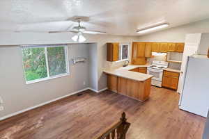 Kitchen featuring white appliances, light hardwood / wood-style flooring, kitchen peninsula, sink, and ceiling fan