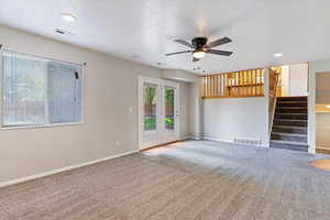 Unfurnished living room featuring ceiling fan, carpet, and a textured ceiling