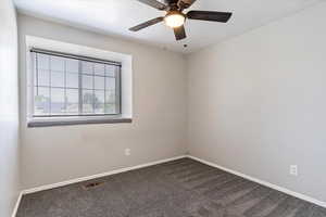 Spare room featuring carpet flooring and ceiling fan