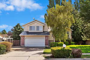 View of front of property featuring a garage and a front yard